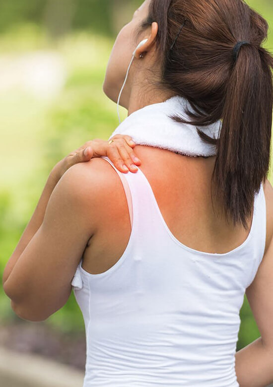 woman holding her shoulder